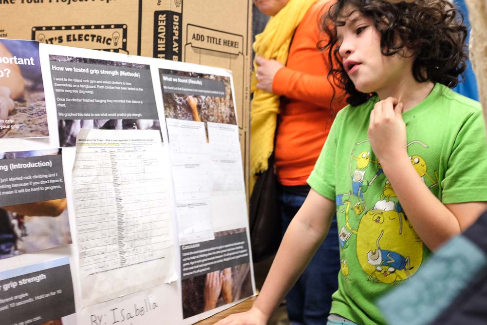 girl in green shirt explains grip strength for 3rd grade science fair project